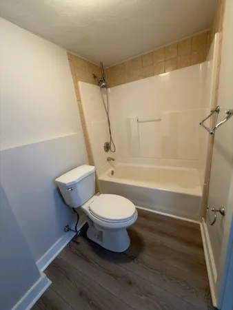a bathroom with a toilet a sink and mirror