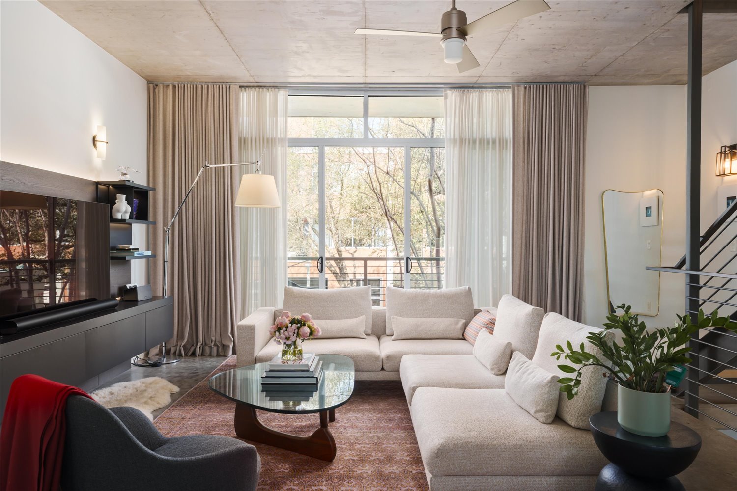 2301 South 5th Street, Unit 11 Austin, TX 78704 - Photo 3 of 24 Floor-to-ceiling windows flood the living room with natural light while framing dynamic 78704 views.