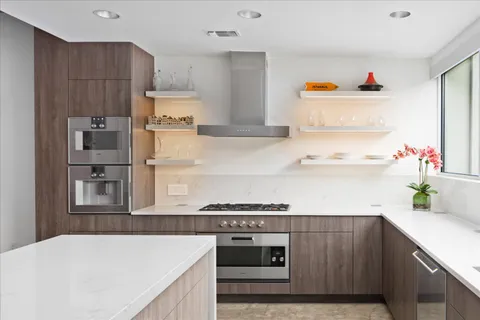 a kitchen with stainless steel appliances granite countertop a refrigerator and a stove