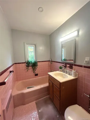 a bathroom with a tub sink and mirror