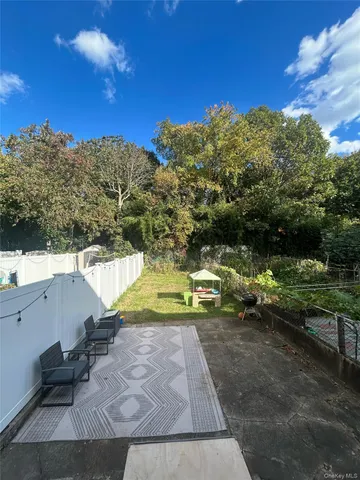 a view of swimming pool with lawn chairs and iron fence