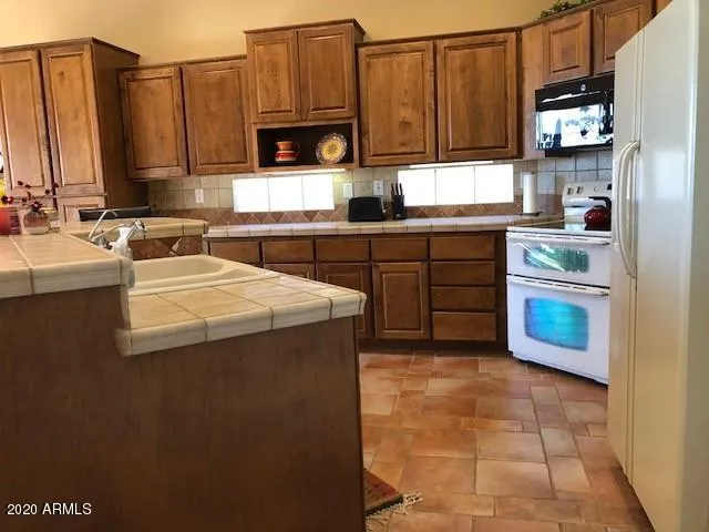 a kitchen with stainless steel appliances granite countertop a sink a stove and a microwave oven with cabinets