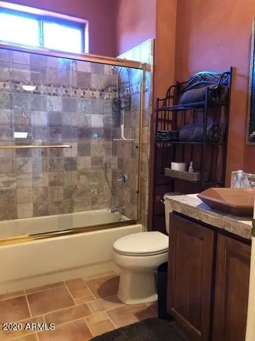 a bathroom with a granite countertop toilet a sink and a shower