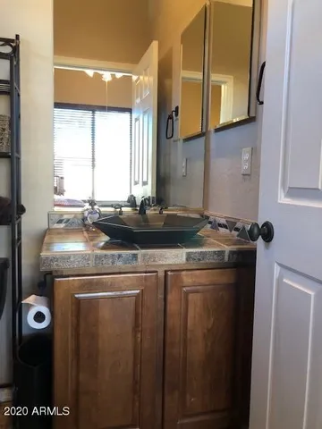 a bathroom with a granite countertop sink and a mirror