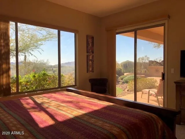 a bedroom with a large window and a bed