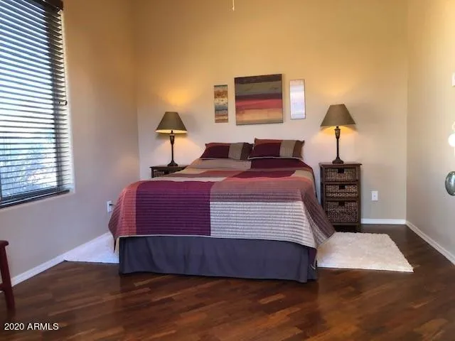 a bedroom with a bed and wooden floor