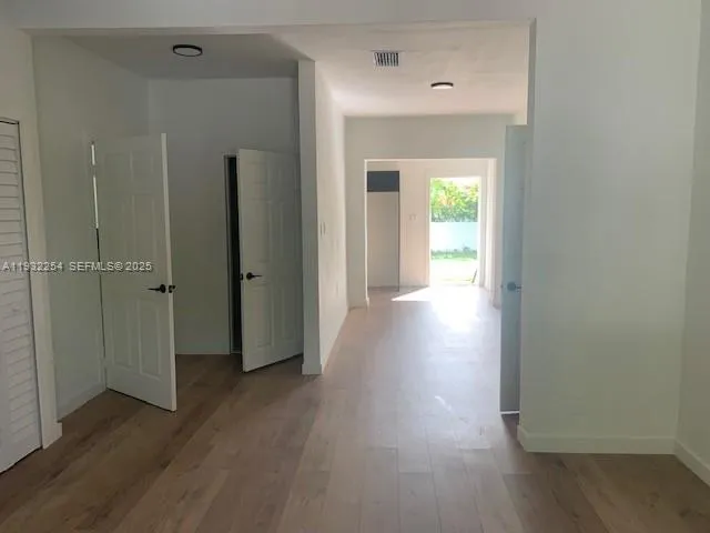 a view of a hallway with wooden floor