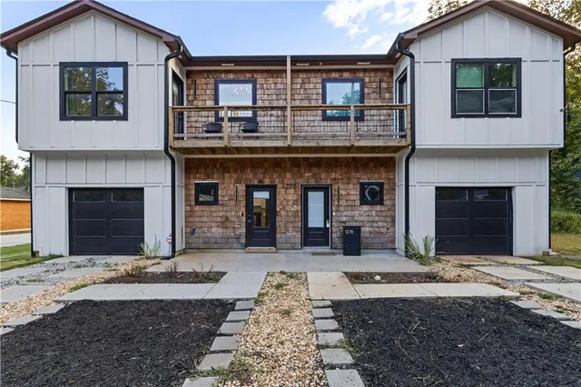a front view of a house with yard and parking space