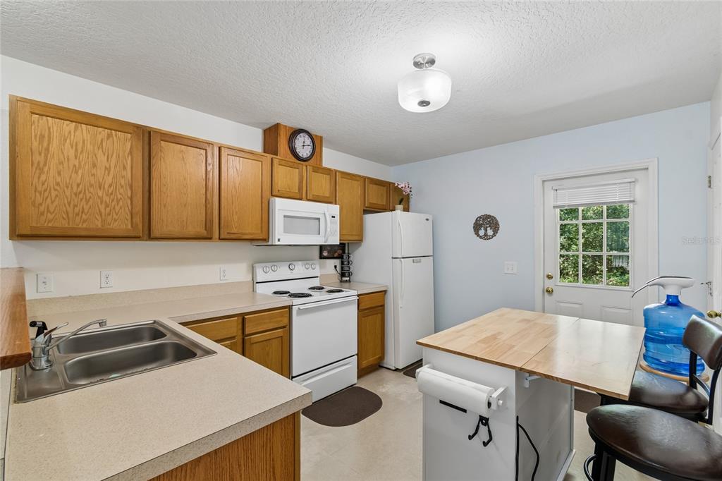 468 North Wheeler Avenue Inverness, FL 34453 - Photo 8 of 24 a kitchen with stainless steel appliances a stove a sink dishwasher and a refrigerator with wooden floor