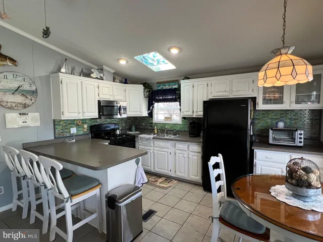 a kitchen with a refrigerator a table and chairs in it