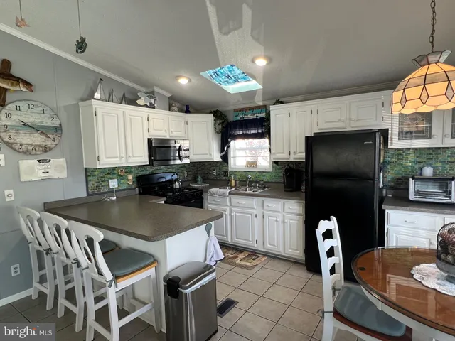 a kitchen with stainless steel appliances granite countertop a table chairs microwave and sink