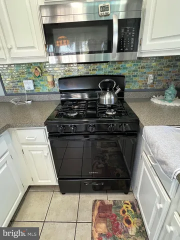 a stove top oven sitting inside of a kitchen