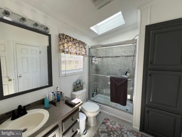 a bathroom with a granite countertop toilet sink and mirror