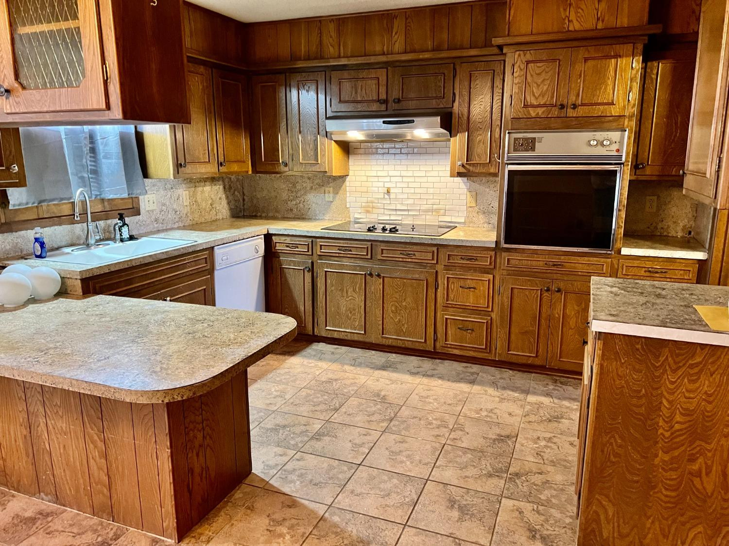 1007 17th Street Ralls, TX 79357 - Photo 12 of 12 a kitchen with stainless steel appliances granite countertop a stove a sink and a microwave