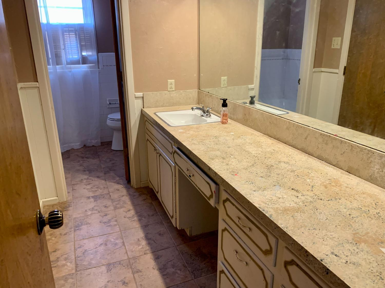 1007 17th Street Ralls, TX 79357 - Photo 8 of 12 a bathroom with a granite countertop sink and a mirror