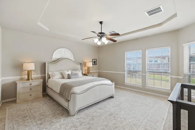 a bedroom with a bed chandelier and a window
