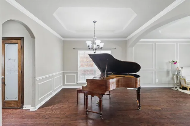 a dining room with furniture a chandelier and wooden floor
