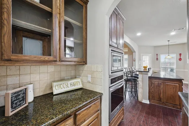 a kitchen with granite countertop stainless steel appliances and wooden cabinets