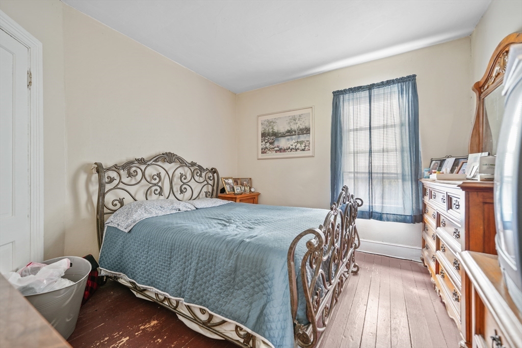 286 Columbia Street Fall River, MA 02721 - Photo 10 of 29 a bedroom with a bed and wooden floor