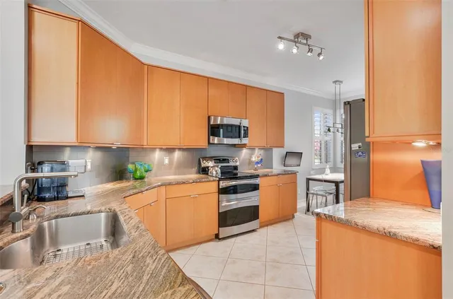 a kitchen with stainless steel appliances granite countertop a refrigerator and a stove