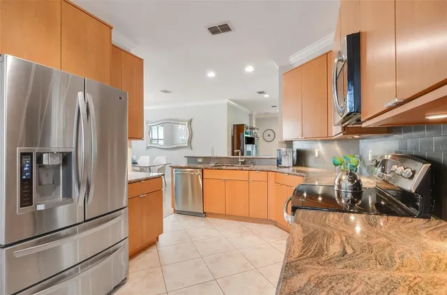 a kitchen with granite countertop a sink stainless steel appliances and cabinets