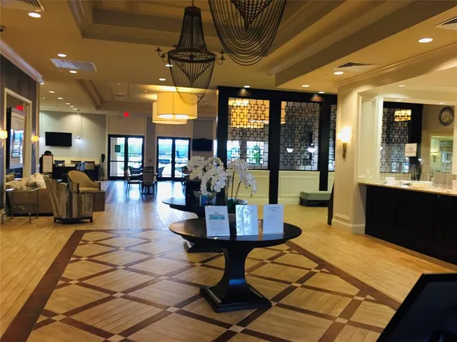 a living room with patio furniture and a chandelier