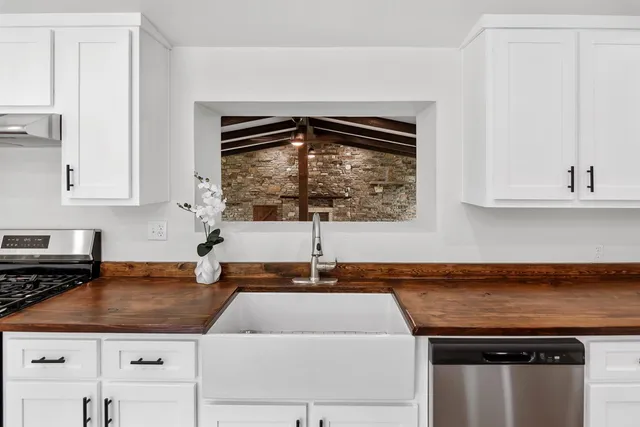 a kitchen with a sink a stove and cabinets