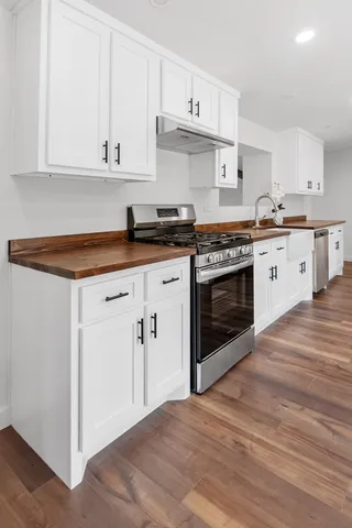 a kitchen with granite countertop white cabinets and white appliances