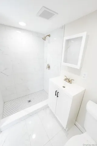 a bathroom with a toilet a sink a shower and mirror