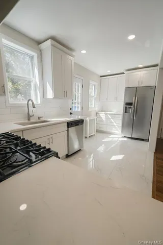 a kitchen with stainless steel appliances granite countertop a stove a sink and a microwave