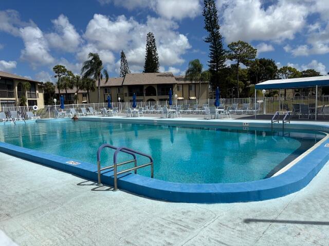 340 Pine Ridge Circle, Unit B1 Greenacres, FL 33463 - Photo 19 of 21 a view of a swimming pool with outdoor seating
