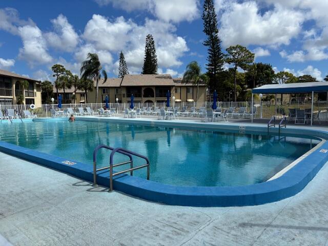 340 Pine Ridge Circle, Unit B1 Greenacres, FL 33463 - Photo 20 of 21 a view of a swimming pool with a patio