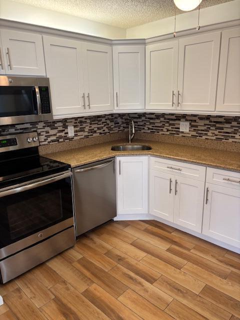 340 Pine Ridge Circle, Unit B1 Greenacres, FL 33463 - Photo 4 of 21 a kitchen with granite countertop white cabinets and stainless steel appliances