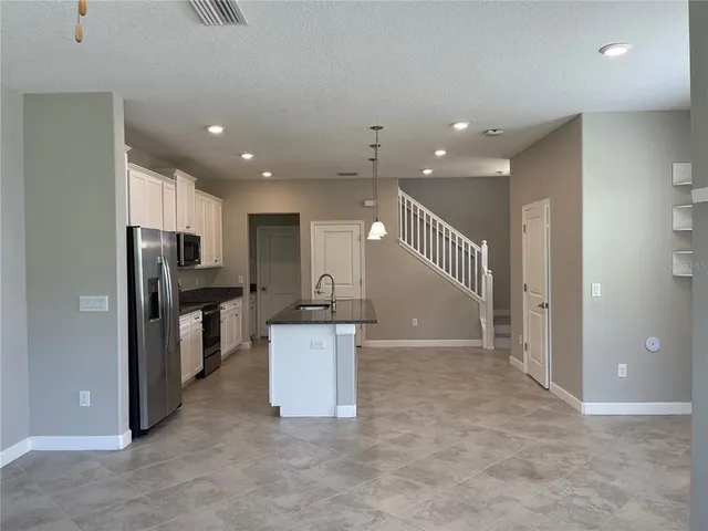 a view of kitchen with refrigerator and microwave