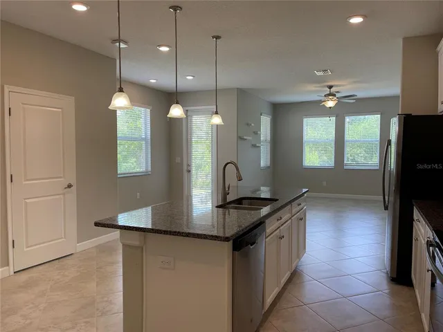a kitchen with kitchen island a sink appliances and a counter top space