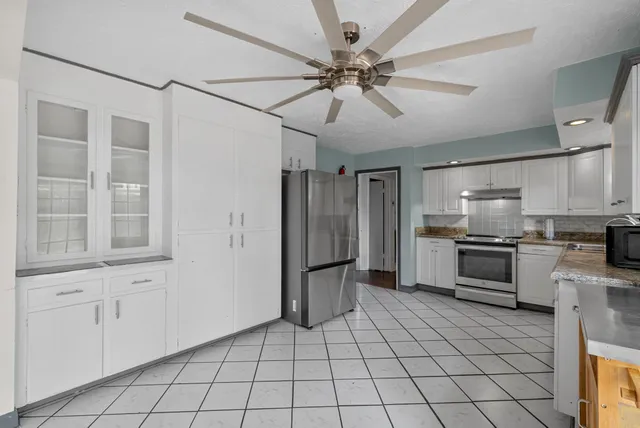 a kitchen with stainless steel appliances a stove a refrigerator and cabinets