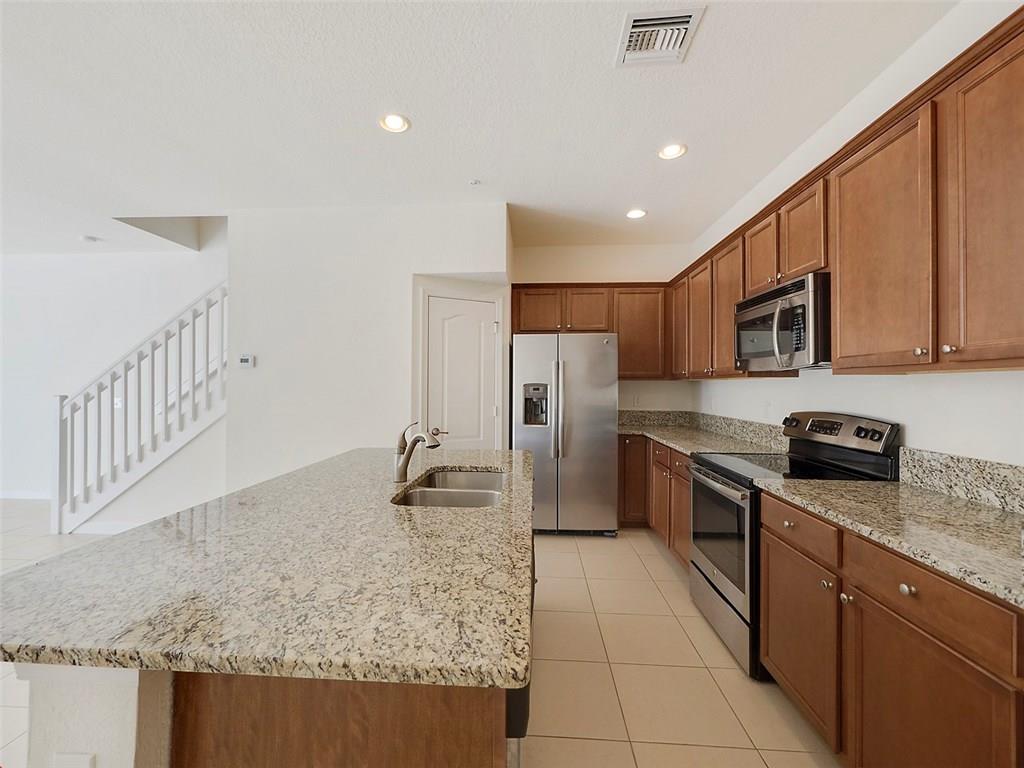 3055 Southwest Otter Lane Stuart, FL 34997 - Photo 4 of 13 a kitchen with stainless steel appliances granite countertop a refrigerator a stove top oven a sink and dishwasher