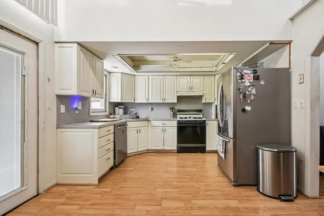 a kitchen with stainless steel appliances granite countertop a refrigerator and a stove