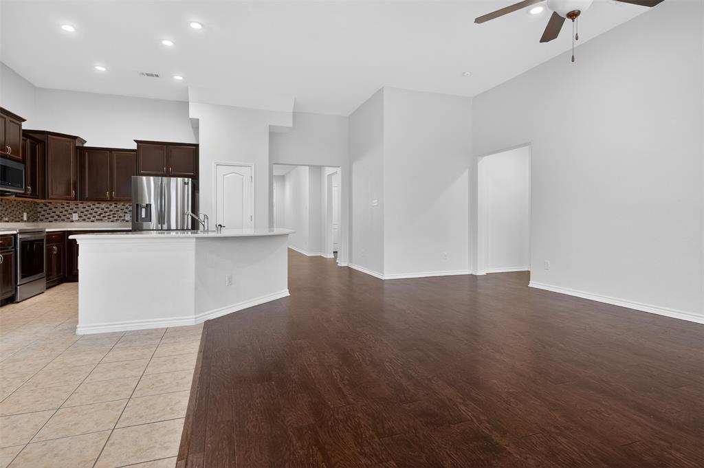 8728 Maple Ridge Trail Fort Worth, TX 76244 - Photo 18 of 40 Open-concept living area featuring rich wood-finish flooring, high ceilings with a ceiling fan, and recessed lighting