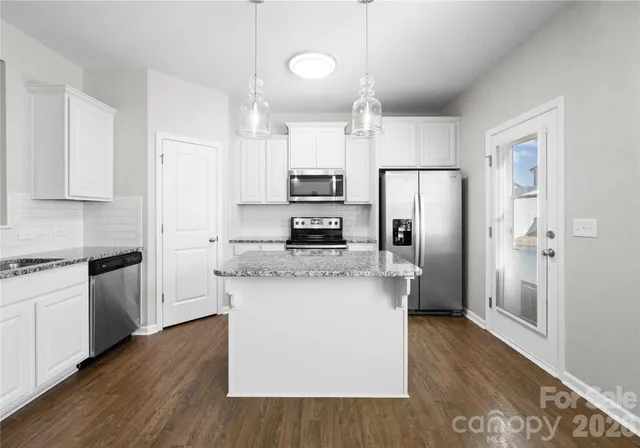 a kitchen with stainless steel appliances a refrigerator and a stove top oven