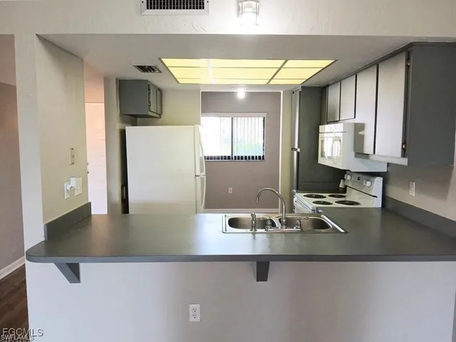 a kitchen with kitchen island a sink appliances and a counter top space