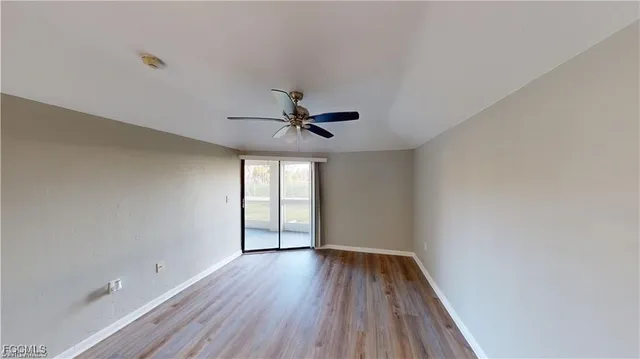 an empty room with a window and ceiling fan