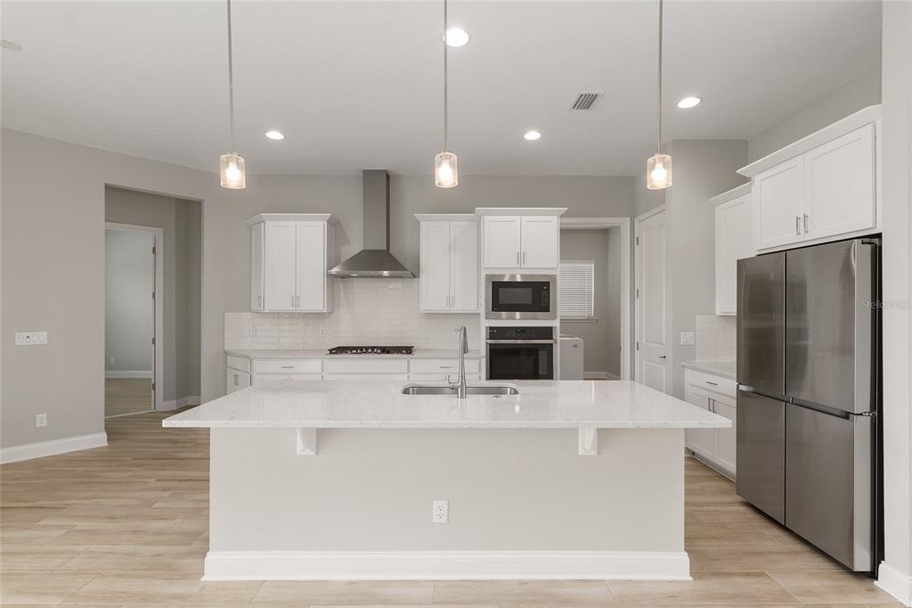 12048 Southwest 35th Place Gainesville, FL 32608 - Photo 12 of 53 a large kitchen with kitchen island a large counter top stainless steel appliances and cabinets