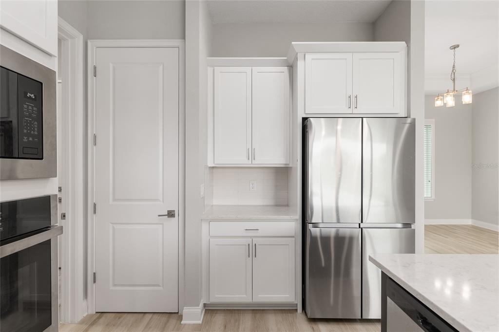 12048 Southwest 35th Place Gainesville, FL 32608 - Photo 16 of 53 a view of a kitchen with refrigerator and wooden cabinets