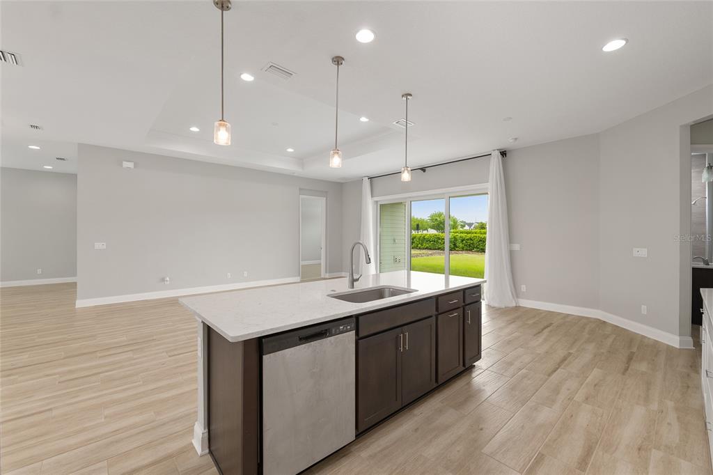 12048 Southwest 35th Place Gainesville, FL 32608 - Photo 17 of 53 a kitchen with kitchen island a sink wooden floor and a large window