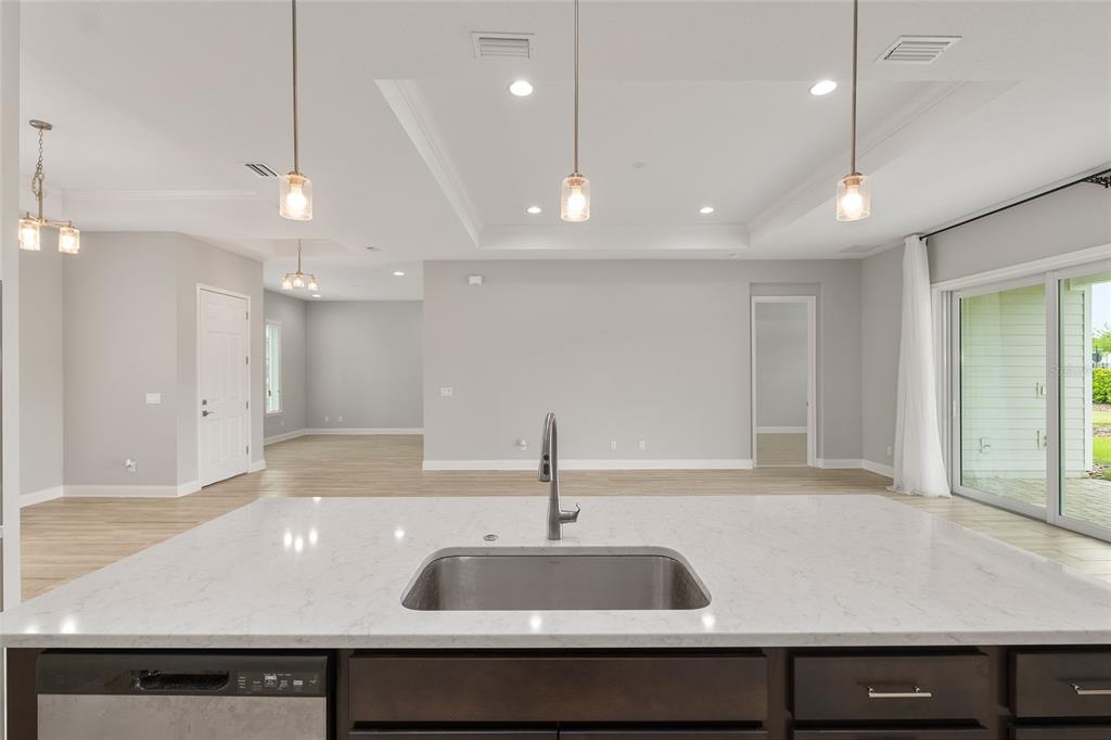 12048 Southwest 35th Place Gainesville, FL 32608 - Photo 18 of 53 a kitchen with kitchen island a sink stainless steel appliances and cabinets
