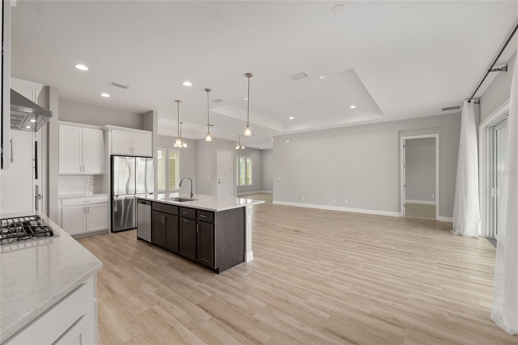 12048 Southwest 35th Place Gainesville, FL 32608 - Photo 20 of 53 a large kitchen with kitchen island a sink stainless steel appliances and cabinets