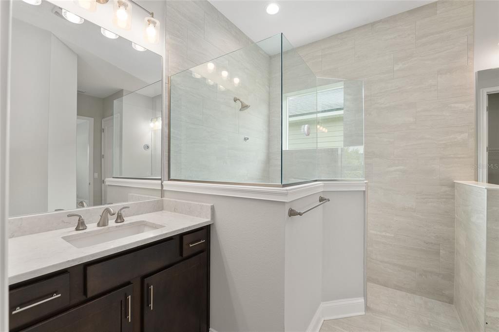 12048 Southwest 35th Place Gainesville, FL 32608 - Photo 22 of 53 a bathroom with a shower sink vanity and mirror