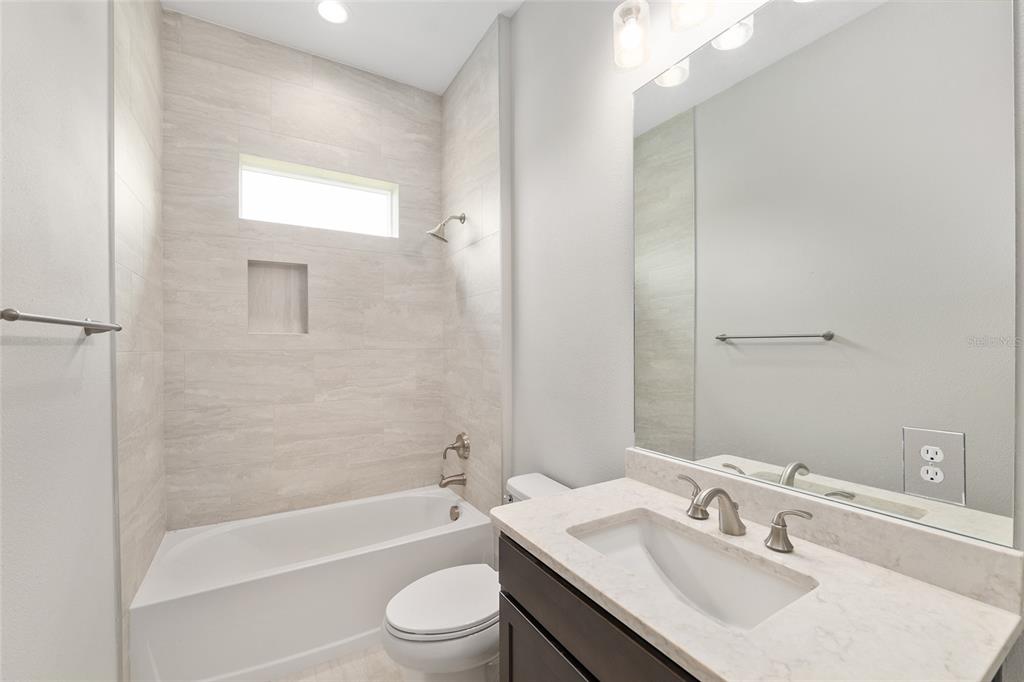 12048 Southwest 35th Place Gainesville, FL 32608 - Photo 35 of 53 a bathroom with a bathtub shower sink vanity mirror and toilet