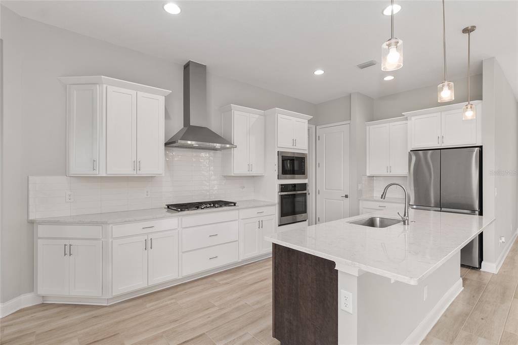 12048 Southwest 35th Place Gainesville, FL 32608 - Photo 4 of 53 a kitchen with stainless steel appliances kitchen island a sink a stove a refrigerator and cabinets